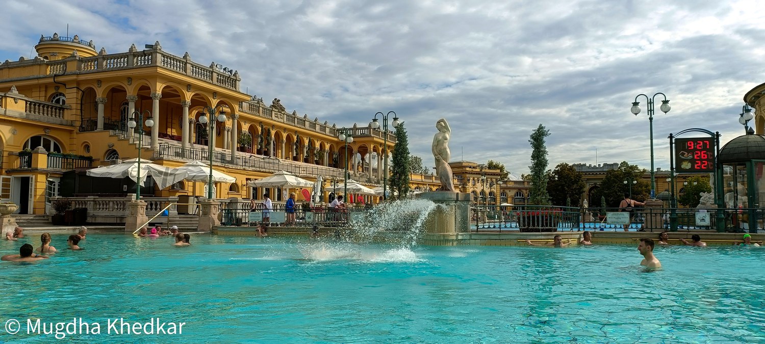 The outdoor pool and yellow buildings of the Széchenyi thermal bath in Budapest