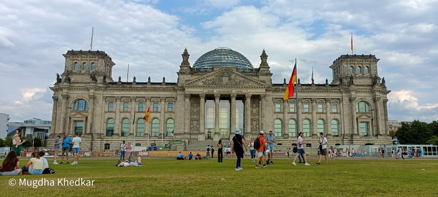 The Reichstag building in Berlin with visitors on the lawn