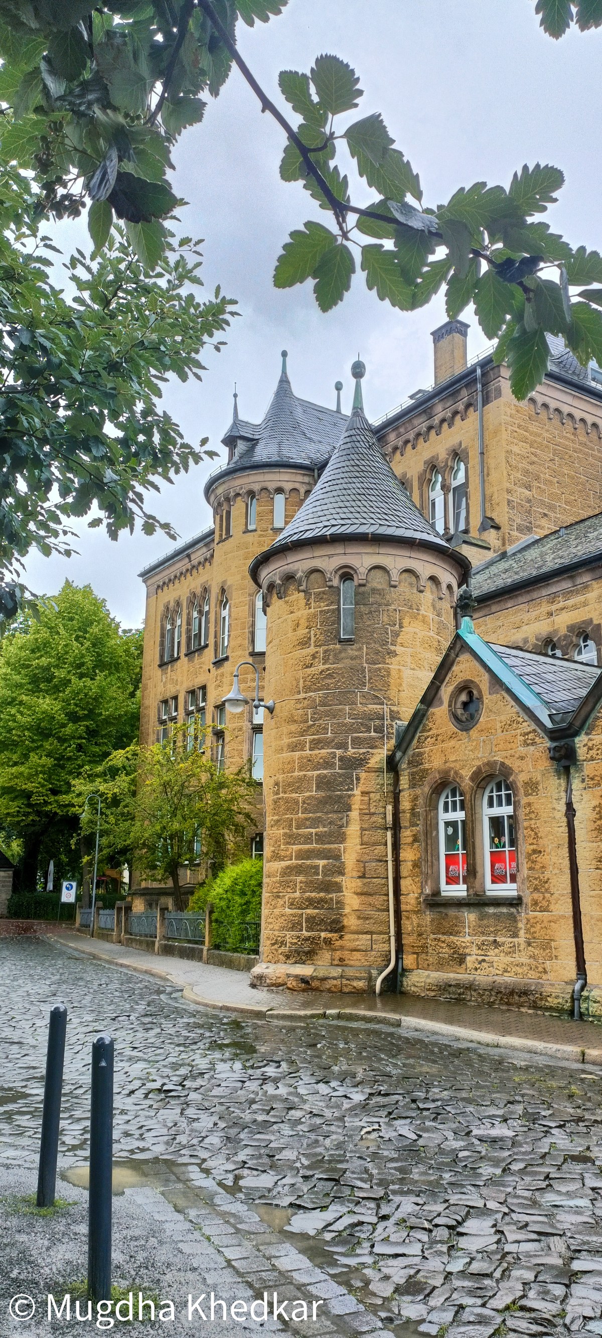 A sandstone building with slate-roofed turrets on a cobbled street in Goslar