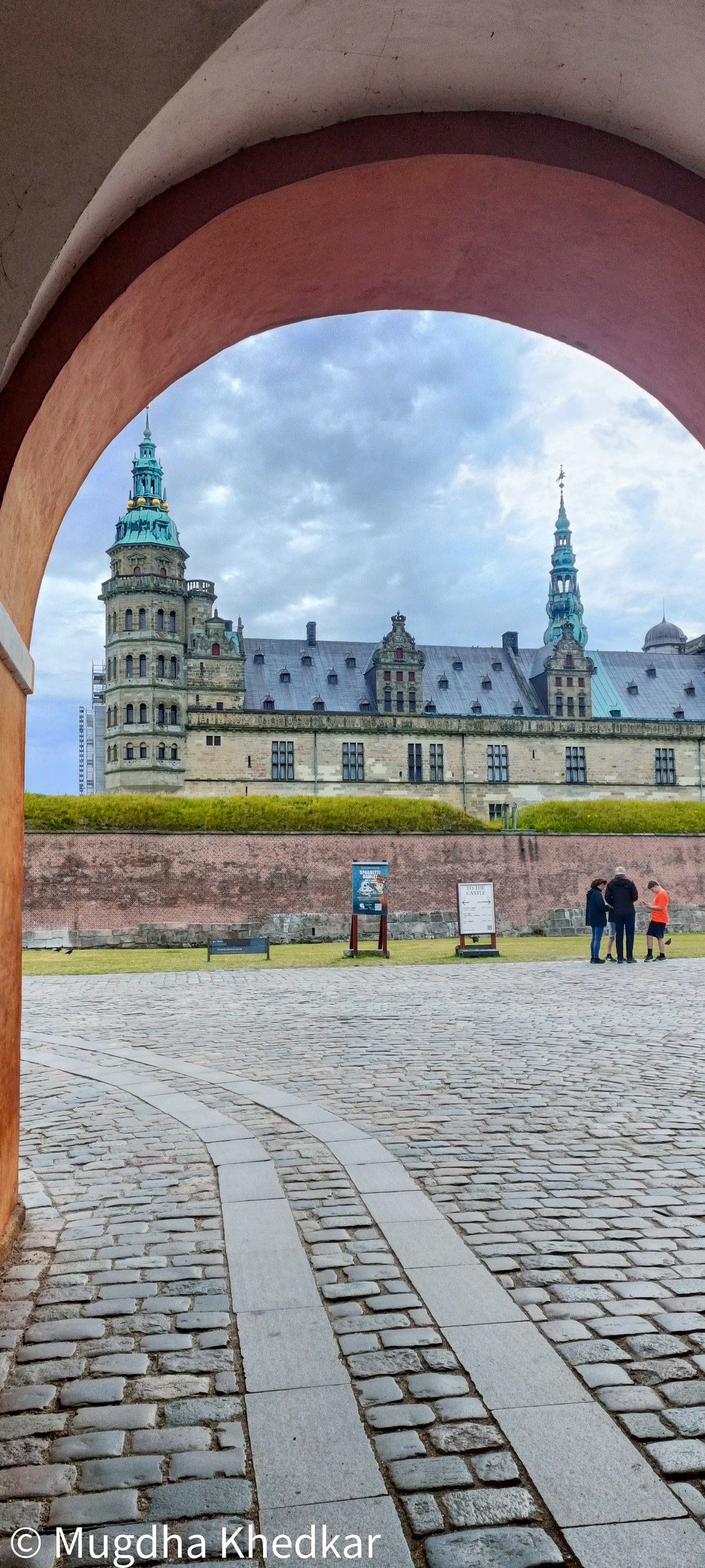 Kronborg Castle in Helsingør seen through a red archway