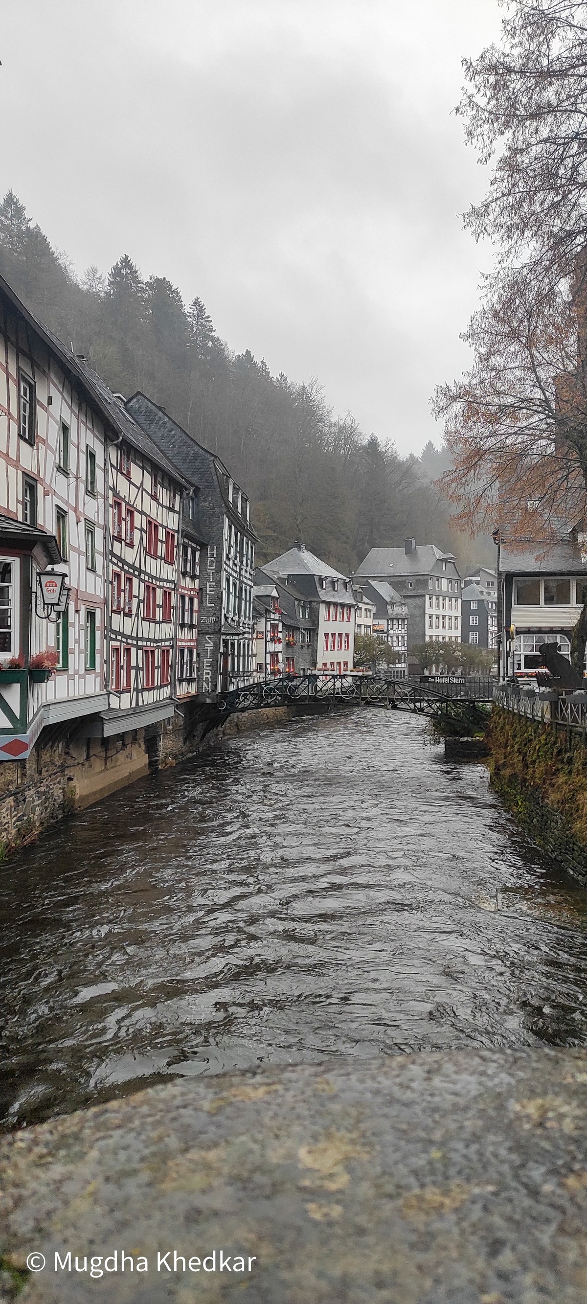 Half-timbered houses lining the Rur river in Monschau on a misty day