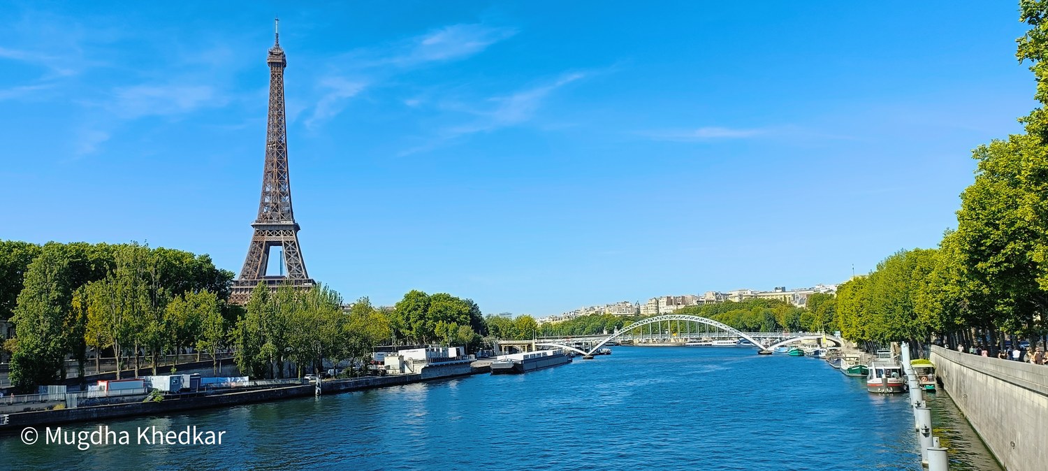 The Eiffel Tower above the Seine on a sunny day