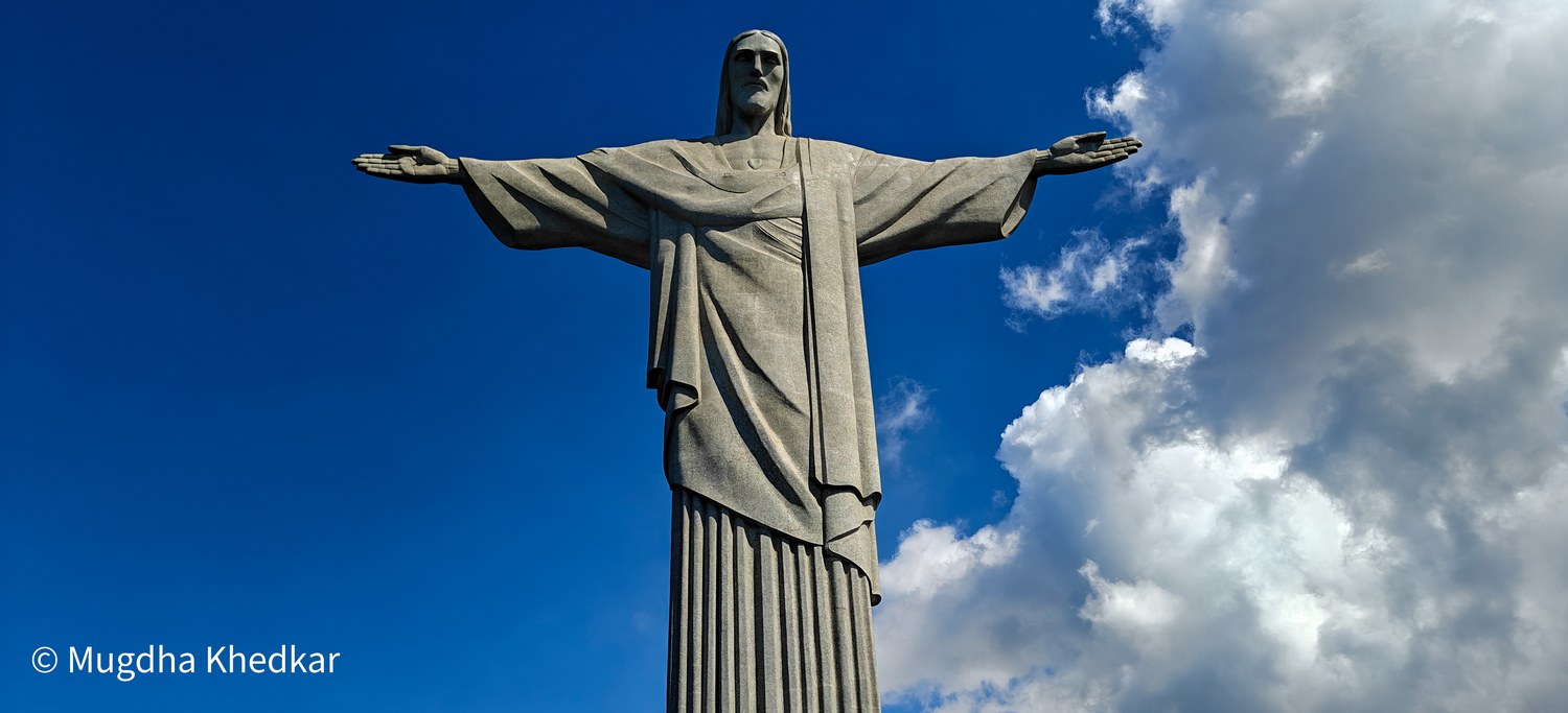 Christ the Redeemer on Corcovado, arms outstretched against a deep blue sky
